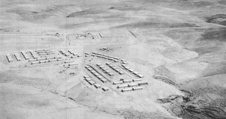 ARAD: Its desolate site on barren desert hills as construction began in the early 1960s. Buildings are temporary structures used to house planners and workers; the beginnings of the street layout for the town are visible, in center. (Israeli gov't. photo)