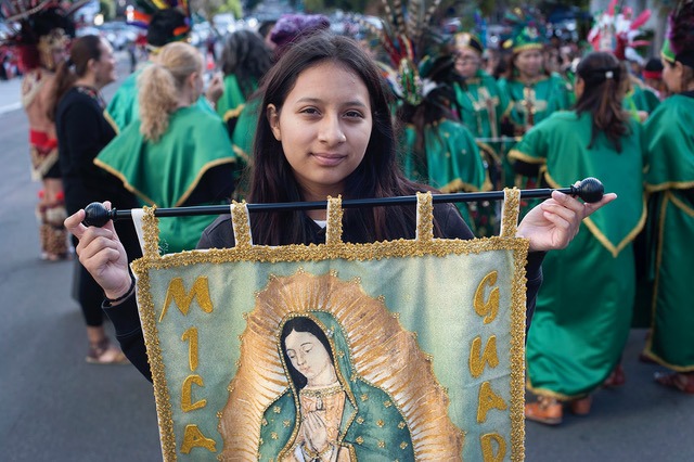 A young woman carries a banner during procession in honor of Our Lady of Guadalupe in December, 2018 in San Diego, California. Photo by David Maung.