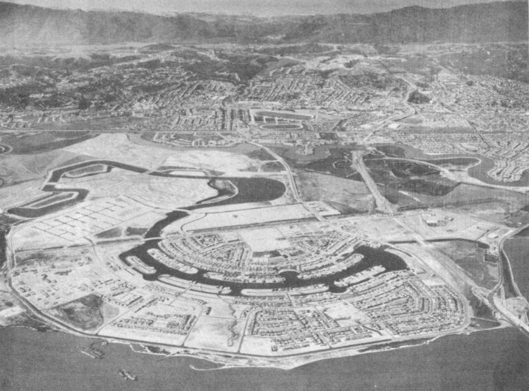 Old aerial photo of Foster City shows islands for homes in the man-made lagoons and, towards middle of picture, the winding channel that cuts the project off from the mainland of the San Francisco peninsula. At top of picture are mountains behind older built-up communities of the crowded San Mateo County suburban sprawl. San Francisco would be to the right of this view, further north on the peninsula. At the bottom of the photo is the bay, with boats dredging fill for the Foster City site visible at lower left. (Foster City aerial photo)