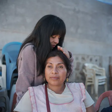 Mayrani Bautista, sister of Benjamín, caresses her mother’s head after the Saint Salvador celebration.