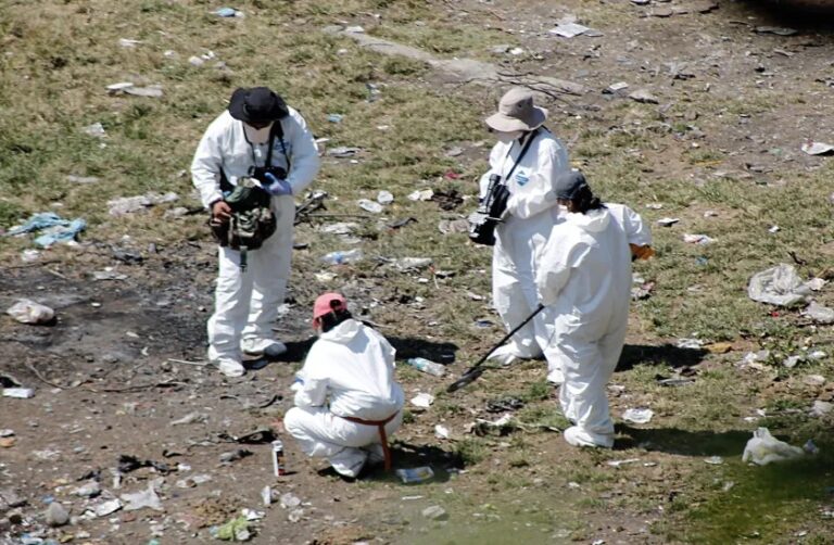 Forensic examiners search for human remains below a garbage-strewn hillside near Cocula, Mexico, on Oct. 28, 2014.Getty Images