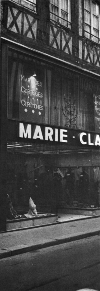 The store facade replaces two stories with plastic, flush at street front, so you have to twist back to be sure it isn't a 1930 building. All Marie Claude is left with is a store on a street that is too narrow.