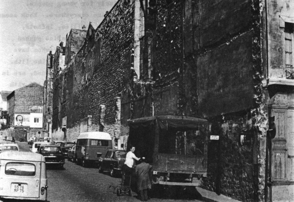 Supplies for a workshop are unloaded beside a block of homes.