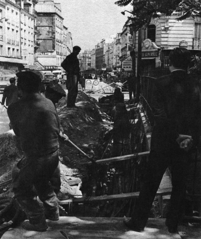 Workmen snake a new electric cable under the street. Modernization continues.