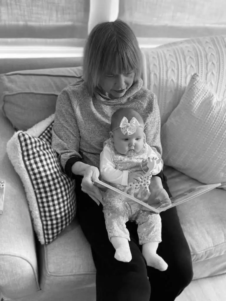 Alva Capuano reads to her granddaughter, Caroline, in April 2022. Visual: Courtesy of Tim Capuano