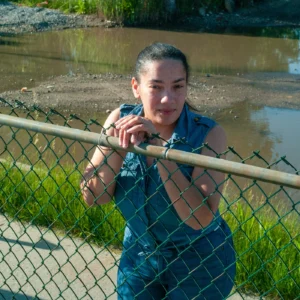 Estefani Nuñez in front of her Rosedale home where she lives with her two children, elderly parents and husband. Nuñez says she experiences flooding from high tides and rainfall. Credit: Damaso Reyes