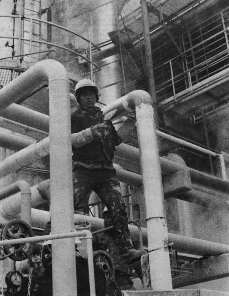 A Korean workman helps put the finishing touches on a refinery.